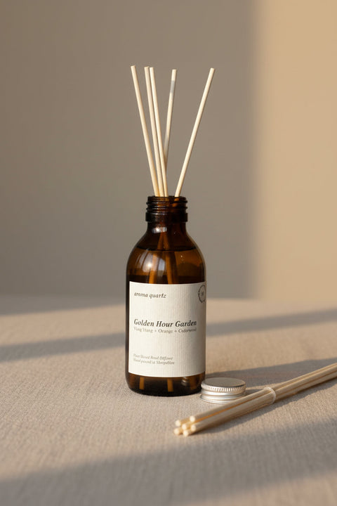 Aroma Quartz amber glass reed diffuser with wooden reeds on a surface