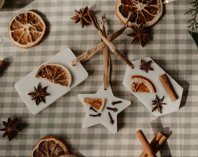 Aroma Quartz scented wax tree decorations in rectangle and star shapes on a gingham cloth with dried orange and star anise