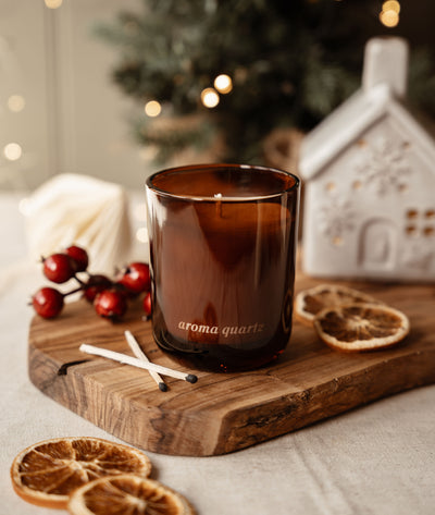 Real Fir Trees candle on a wooden board with a ceramic house, red berries and dried orange slices