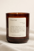 Velvet Oud candle with a label on a beige fabric background