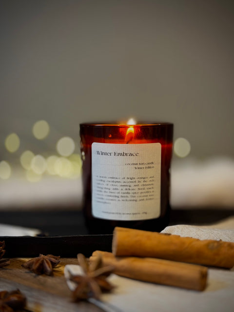 Winter Embrace Aroma Quartz candle in brown glass jar on wooden surface