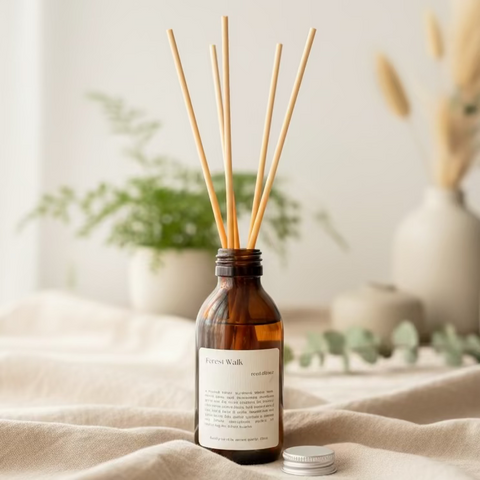 A natural Diffuser bottle with wooden reed on a wooden surface on a grey background, the diffuser bottle has a cream textured label