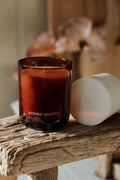 Red candle labeled 'aroma quartz' on a wooden surface with blurred background