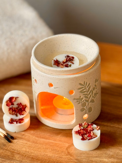 Ceramic wax warmer with three wax melts on a wooden surface