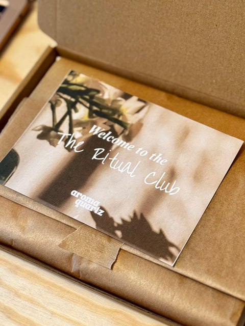 A box of our monthly melt subscription with a Card that says 'Welcome to the Ritual Club' text inside an open cardboard box.
